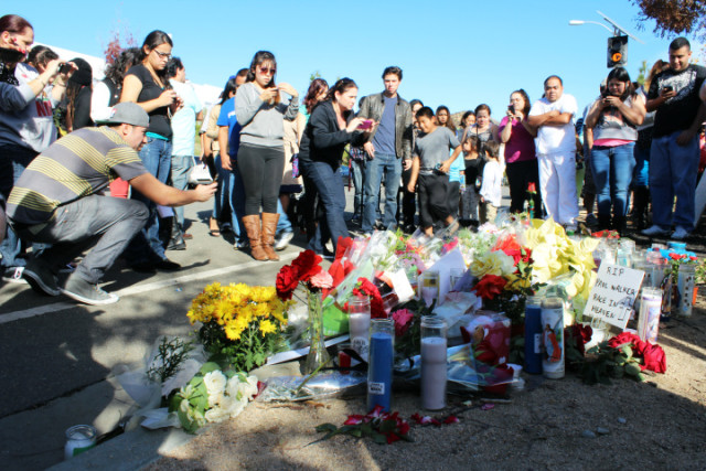 People gather at the roadside memorial for actor Paul Walker in Valencia, Calif. on Sunday, Dec. 1, 2013. Walker is believed to have been a passenger in the car that crashed and burned on Saturday, Nov. 30, 2013 as a charity event at a nearby car shop was winding down.(AP Photo/The Santa Clarita Valley Signal, Ryan Fonseca)