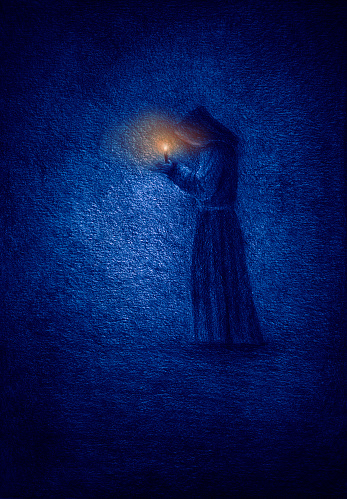 Lonely monk in a cave with a candle