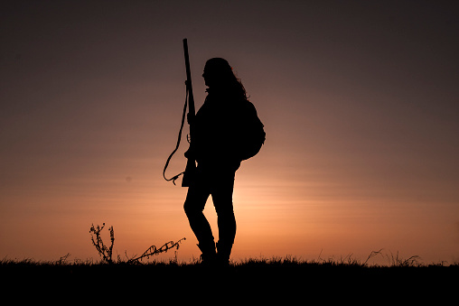 Woman Hunter Silhouetted in Sunset