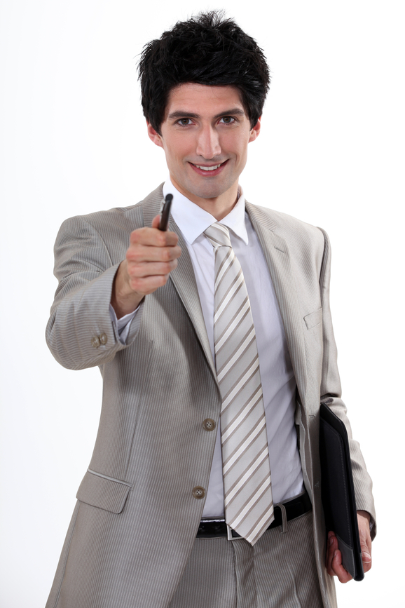 Usmievajúci muž v obleku drží pero