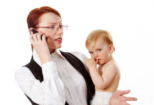 Telefonujúca podnikateľka s dieťaťom na rukách