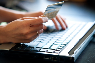 Žena zadávajúca čísla z kreditnej karty do počítača