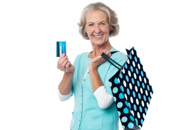 Dôchodkyňa s taškou na pleci držiaca kreditnú kartu