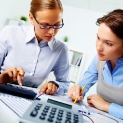 Dve ženy počítajúce na kalkulačke