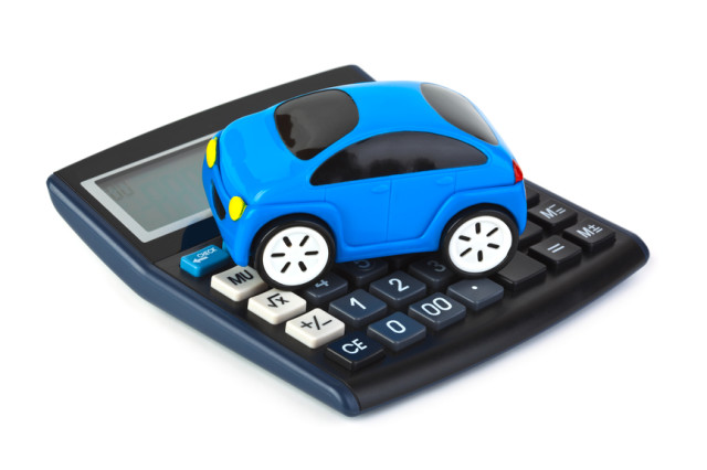 Modré hračkárske autíčko položené na kalkulačke