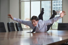 Playful Businessman Laying on Table