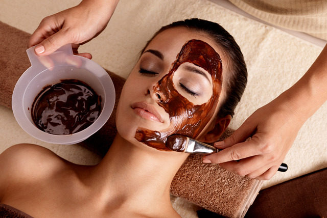 Spa therapy for woman receiving cosmetic mask