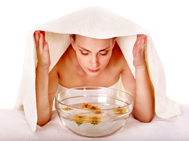 35974975 - facial massage with steam treatment.towel on head