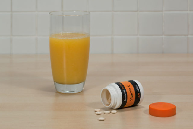 Vitamin c tablets and glass of orange juice
