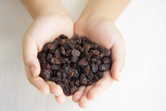 Child holding a handful of raisins