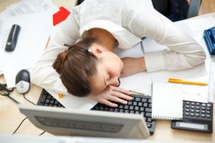 Žena spiaca na pracovnom stole