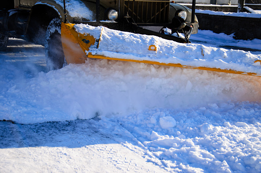 Snow plow truck workiyng in a city park. Kremenchug, Ukraine