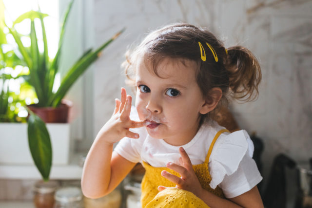Cute Little Girl Eating Whipped Cream