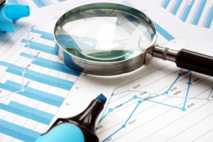 Magnifying glass and financial documents. Audit and accounting.