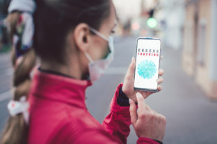 Woman using a phone with the coronavirus tracking app installed