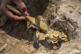 Israeli archaeologist Shahar Krispin cleans gold coins that was discovered at an archeological site in central Israel, Tuesday, Aug 18, 2020. Israeli archaeologists have announced the discovery of a trove of early Islamic gold coins during recent salvage excavations near the central city of Yavn Tel Aviv. The collection of 425 complete gold coins, most dating to the Abbasid period around 1,100 years ago, is a "extremely rare" find. ()