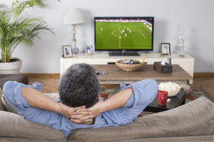 Man watching football match at home