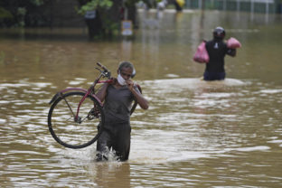 Sri Lanka Rains A Sri Lankan man wades through a flooded road carrying his bicycle in Kochchikade, about 30 kilometres north of Colombo, Sri Lanka, Wednesday, Nov. 10, 2021. At least 16 people have died in floods and mudslides in Sri Lanka following more than a week of heavy rain, officials said Wednesday.