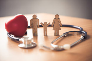 Medical Insurance Concept With Family  And Stethoscope On Wooden Desk