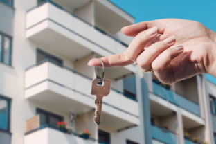 Real estate agent holding keys to new flat