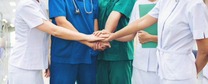 Cooperation of people in the medical community teamwork with a hands together