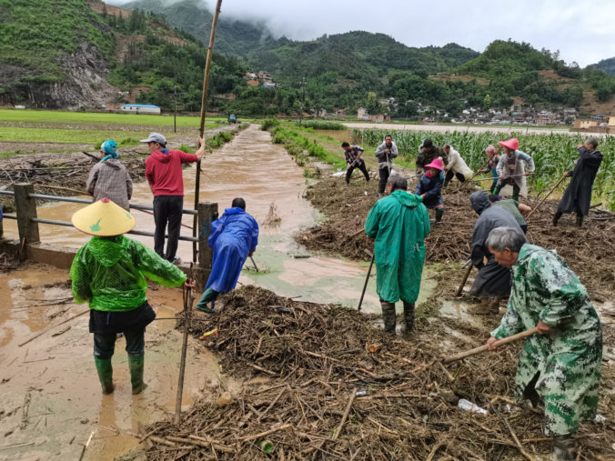 In this photo released by China's Xinhua News Agency, people work in a flooded area in Qiubei County in southwestern China's Yunnan Province, Friday, May 27, 2022. More than a dozen people have died in torrential rains across southern China, state media reported Saturday