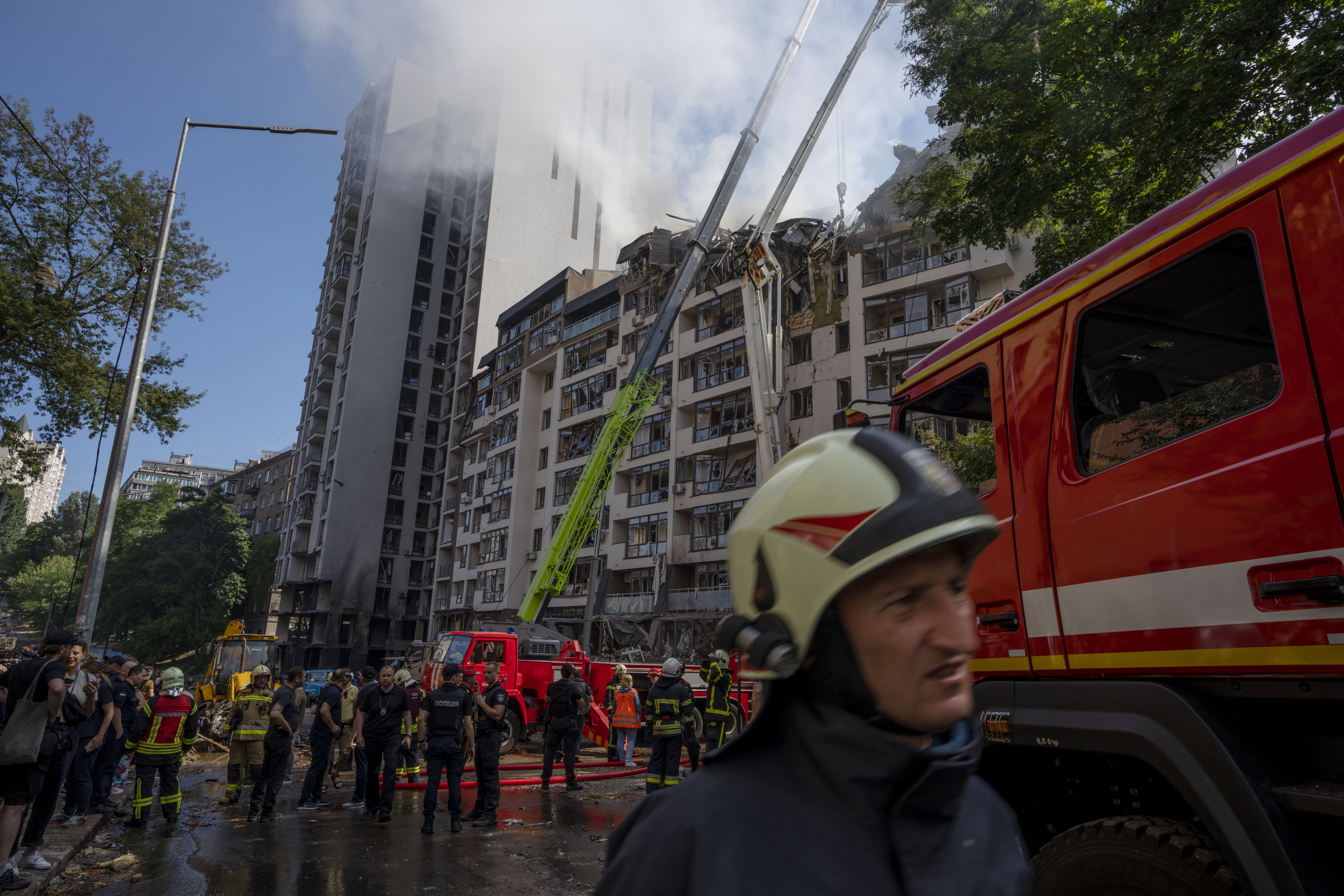 Firefighters work at the scene of a residential building following explosions, in Kyiv, Ukraine, Sunday, June 26, 2022. Several explosions rocked the west of the Ukrainian capital in the early hours of Sunday morning, with at least two residential buildings struck, according to Kyiv mayor Vitali Klitschko