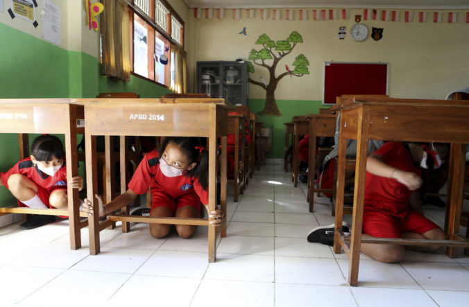Elementary students shelter under their desks during an emergency drill that assumed a major earthquake and tsunami in Bali, Indonesia on Tuesday, May 24, 2022. ()