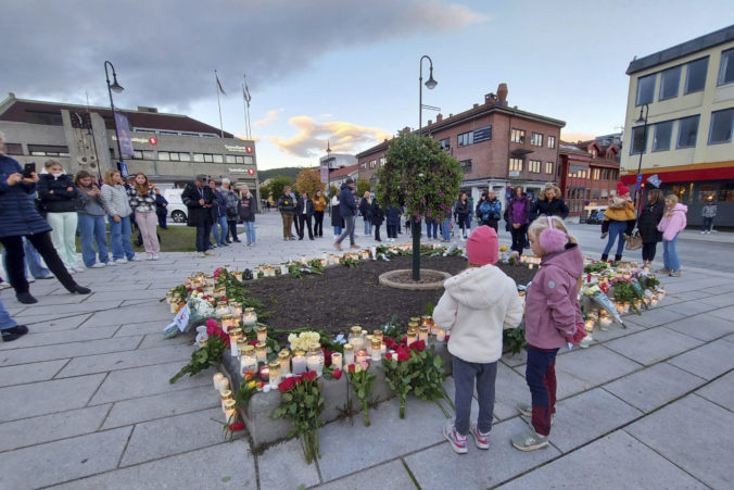 FILE - People gather around flowers and candles after a man killed several people on Wednesday afternoon, in Kongsberg, Norway, Thursday, Oct. 14, 2021. A man was Friday, June 24, 2022 found guilty to murder and attempted murder for fatally stabbing five and wounding four others in southern Norway when he attacked strangers with a bow and arrows and knives