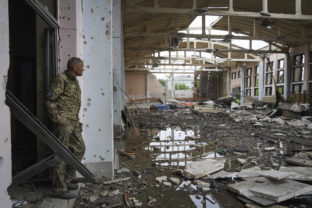 A Ukrainian serviceman looks at the ruins of the sports complex of the National Technical University in Kharkiv, Ukraine, Friday, June 24, 2022, damaged during a night shelling.