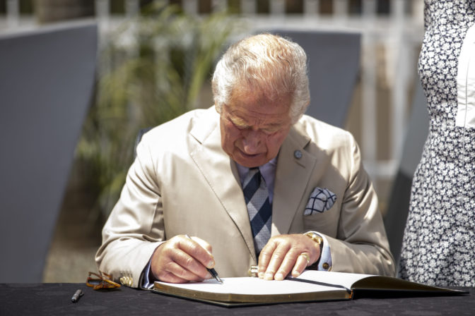 Britain's Prince Charles signs the visitors book at the Kigali Genocide Memorial in the capital Kigali, Rwanda Wednesday, June 22, 2022. Prince Charles has become the first British royal to visit Rwanda, representing Queen Elizabeth II as the ceremonial head of the Commonwealth at a summit where both the 54-nation bloc and the monarchy face uncertainty