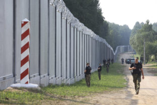 FILE - Polish border guards patrol the area of a newly built metal wall on the border between Poland and Belarus, near Kuznice, Poland, Thursday, June 30, 2022. Polish officials said on Thursday, Aug. 4, 2022, that most of those seeking to enter Poland illegally now are Africans who first traveled to Russia, instead of people from the Mideast. ()