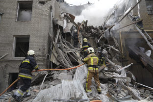 Ukrainian firefighters work on a destroyed building after today's Russian rocket attack in center Kharkiv, Ukraine