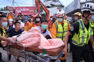 In this photo provided by Hualien City Government, a trapped victim is carried on a stretcher as the victim was found and rescued by firefighters from a collapsed building in Yuli township, Hualien County, eastern Taiwan, Sunday, Sept. 18, 2022. A strong earthquake shook much of Taiwan on Sunday, toppling at least one building and trapping two people inside and knocking part of a passenger train off its tracks at a station