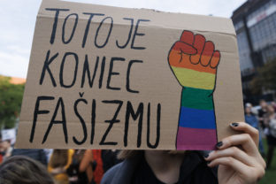 Účastníčka s transparentom počas zhromaždenia Zostávame v uliciach na vyjadrenie podpory queer komunite po stredajšej vražde dvoch mladých ľudí, Juraja a Matúša, na Námestí SNP. Bratislava, 16. október 2022.
