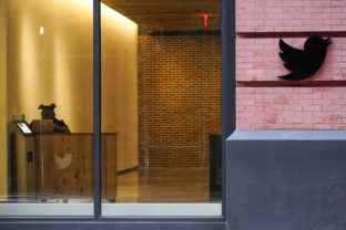 A receptionist works in the lobby of the building that houses the Twitter office in New York, Wednesday, Oct. 26, 2022. Elon Musk posted a video Wednesday showing him strolling into Twitter headquarters ahead of a Friday deadline to close his $44 billion deal to buy the company