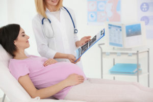 Gynecologist,Showing,Ultrasound,Photo,To,Pregnant,Woman