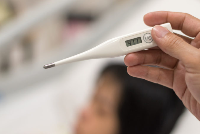 High fever or High fever or hyperpyrexia concept. Thermometer with temperature 41.1Â°C Centigrade with blur background of child sleep on hospital bed hyperpyrexia concept. Thermometer with temperature 41.1Â°C Centigrade with blur background of child sleep on hospital bed