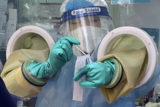 Virus Outbreak FILE - A worker handles a coronavirus test sample at a private testing site in Beijing, Wednesday, Jan. 26, 2022. The official global death toll from COVID 19 is on the verge of eclipsing 6 million — underscoring that the pandemic, now in its third year, is far from over 6 Million Deaths